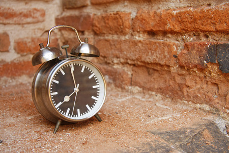 still life with vintage retro alarm clock on old brick backgroundの写真素材