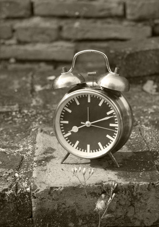 still life with vintage retro alarm clock on old brick background (black and white concept )の写真素材