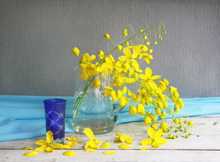 Still life with vase of golden shower tree flower on wooden table.の写真素材
