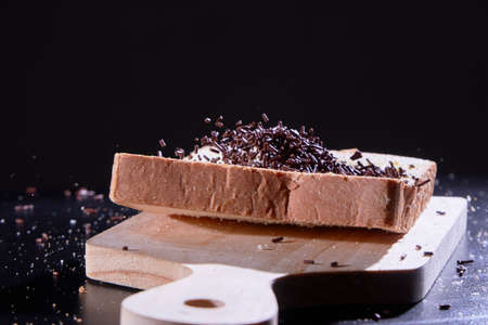 Chocolate sprinkles on sliced bread that fell onto a board.の写真素材