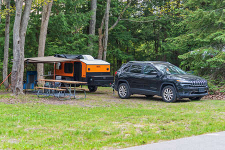 Small teardrop travel trailer parked at a state campground siteのeditorial素材