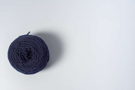 Large dark blue ball of yarn on white background
