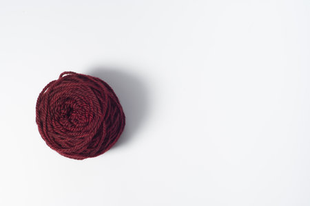 Large dark red ball of yarn on white backgroundの写真素材