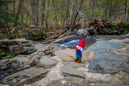 Gnome hiking in the mountains at a stream