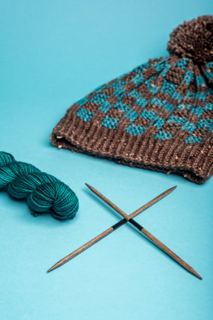 Blue and brown winter hat with a checkered pattern on a blue background closeup.