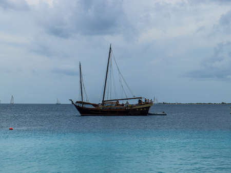 BONAIRE - OCTOBER 11, 2013: Cloudy Caribbean evening with sailboat silhouettedのeditorial素材