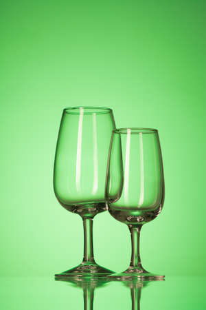 two empty glasses for cocktail on the green backgroundの写真素材