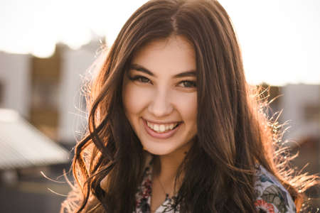 beautiful brunette on the roof of a house at sunriseの写真素材