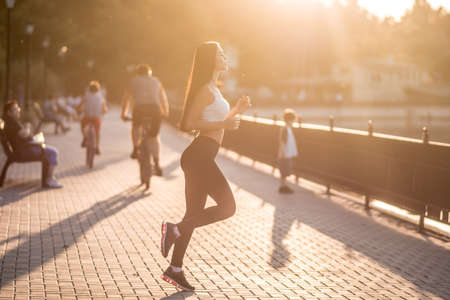 beautiful brunette doing fitness on the background of the lakeの写真素材