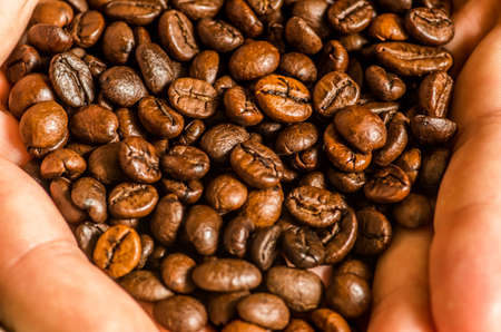 coffee beans macro on the hands of a manの写真素材