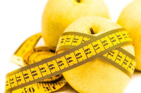 wet yellow pear macro on white background with a tape measureの写真素材