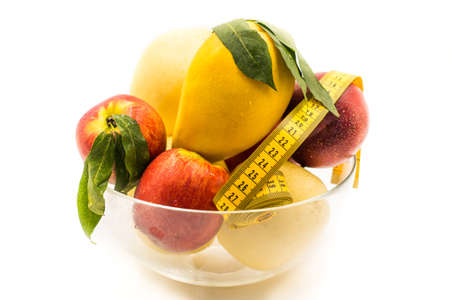 different fruit in a crystal round vase isolated on white backgroundの写真素材