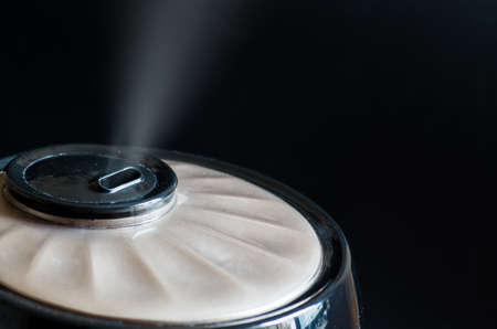 black air humidifier with steam on black backgroundの写真素材