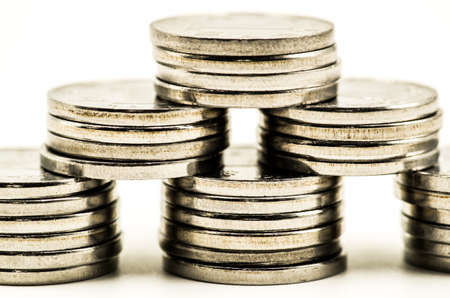 piles pyramide of coins on white backgroundの写真素材