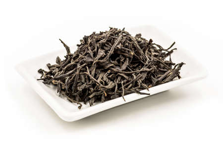 black tea leaves on the white rectangular plate on the white backgroundの写真素材