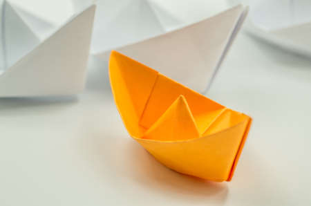 origami ship with following ships behind on whiteの写真素材