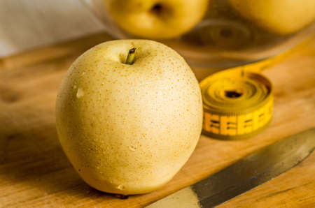 wet yellow pear macro on wooden cutting boardの写真素材