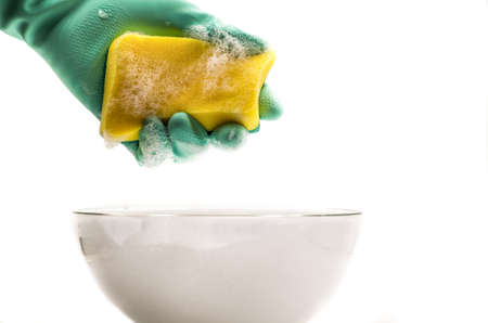 hand in a rubber glove holds a yellow cleaning spongeの写真素材
