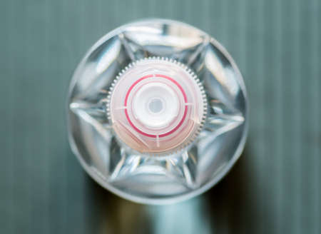 clear plastic bottle with a red and white cap on dark backgroundの写真素材