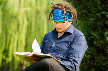 a male is reading outdoorの写真素材