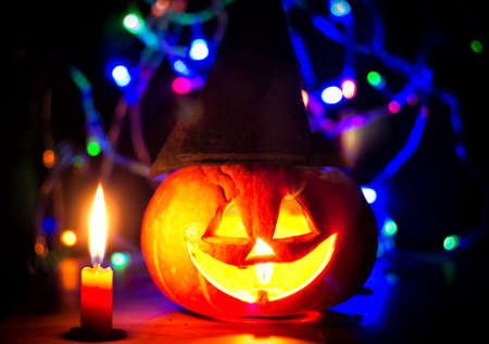 spooky halloween pumpkin with candles and shiny backgroundの写真素材