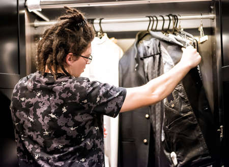 young man chooses clothes in a wardrobeの写真素材