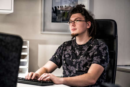 european man with afro hairstyle working with computer in the office. office worker. business...
