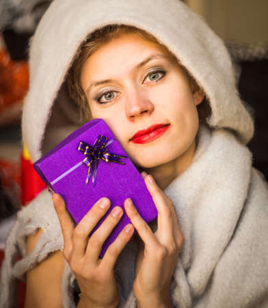 young caucasian womanis holding a gift in her hands. woman celebrating holiday with presentの写真素材
