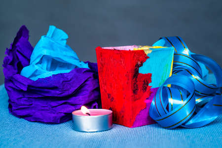 christmas craft composition on the blue tablecloth. candle with fir tree branch, crepe paper and blue tableclothの写真素材