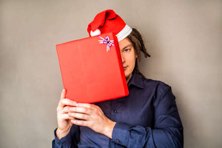 young european man in christmas hat with a giftの写真素材