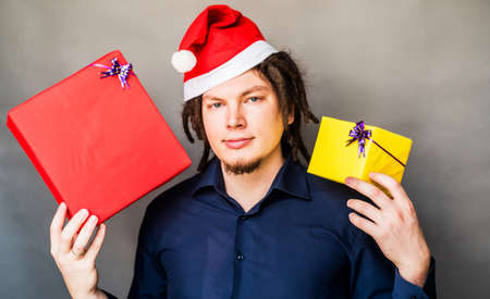 young caucasian man with afro hair holding christmas presents. christmas conceptの写真素材