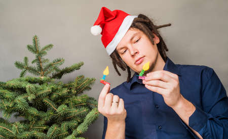 Young man in Santa hat looking at Christmas craftの写真素材