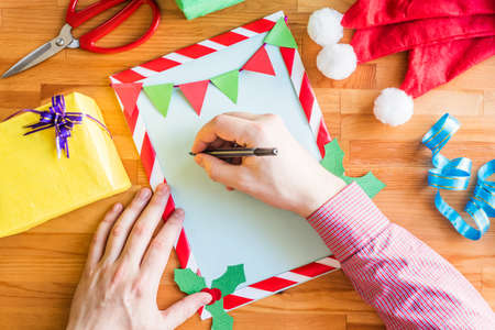 christmas style to do list. man hand writing on a decorated sheet of paperの写真素材