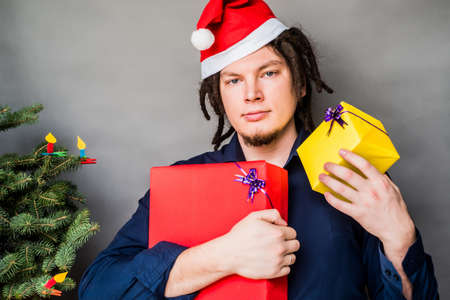 young caucasian man with afro hair holding christmas presents. christmas conceptの写真素材