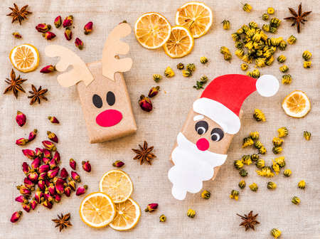 vintage christmas craft gift boxes on linen table cloth with slices of lemon and spicesの写真素材