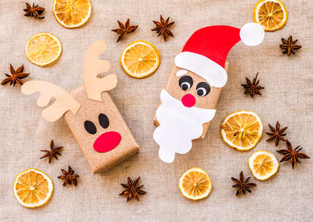 two gift boxes from recycled paper on linen background with lemon and spices. ecological christmasの写真素材