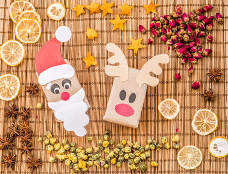 Christmas hand made reindeer and santa gift boxes, top view. Christmas or new year holiday background. Christmas present on wooden table cloth backgroundの写真素材