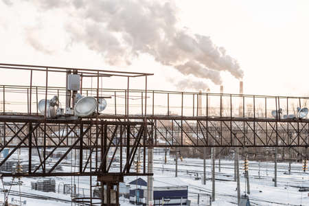 railway station in industrial area with smoking chimneyの写真素材