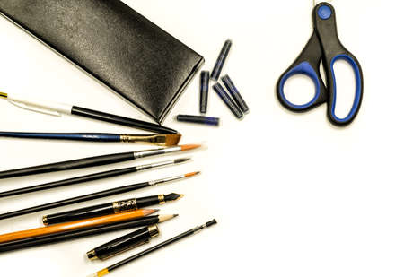 office supplies in black colors isolated on white. ink pen, brushes, scissors, pencils on white. writing and drawing toolsの写真素材