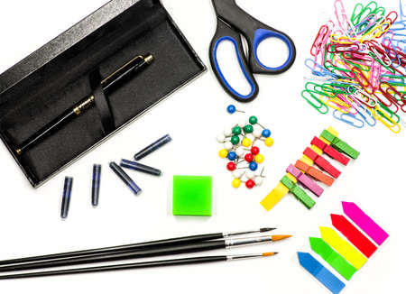 office supplies on white. ink pen, brushes, scissors, pencils, eraser, paper clips and bookmarks on white. writing and drawing toolsの写真素材