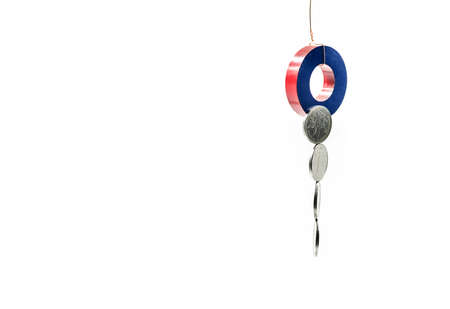 a round magnet tied to a rope collecting money over whiteの写真素材