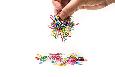 magnet covered with colorful paper clips in a hand of a manの写真素材