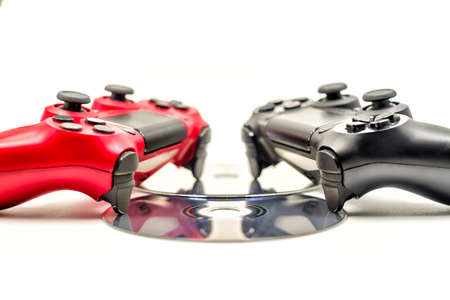 red and black game pads with cds isolated on backgroundの写真素材