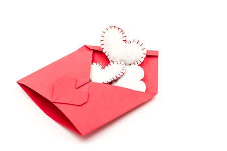 red envelope filled with white hearts isolated on whiteの写真素材