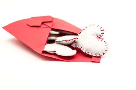 red envelope filled with white hearts isolated on whiteの写真素材