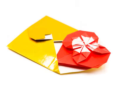 golden origami envelope with red paper heart isolated on whiteの写真素材
