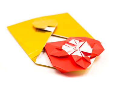 golden origami envelope with red paper heart lay isolated on whiteの写真素材