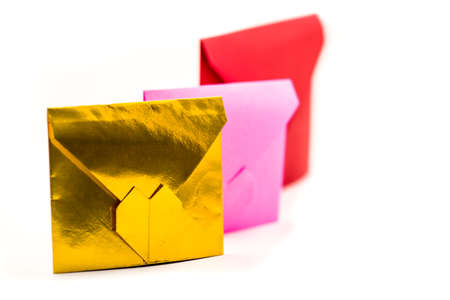 valentine's day concept. pile of colorful origami paper envelopes isolated on white. pink, red and gold envelopes lay on white backgroundの写真素材
