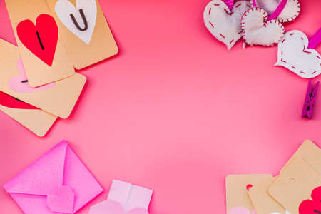 valentines day holiday. hand made decorations for a valentine day on pink background. i love you labels, hearts and origami envelopesの写真素材