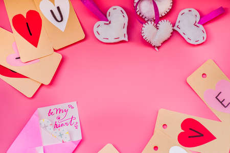 valentines day holiday. hand made decorations for a valentine day on pink background. i love you labels, hearts and origami envelopesの写真素材
